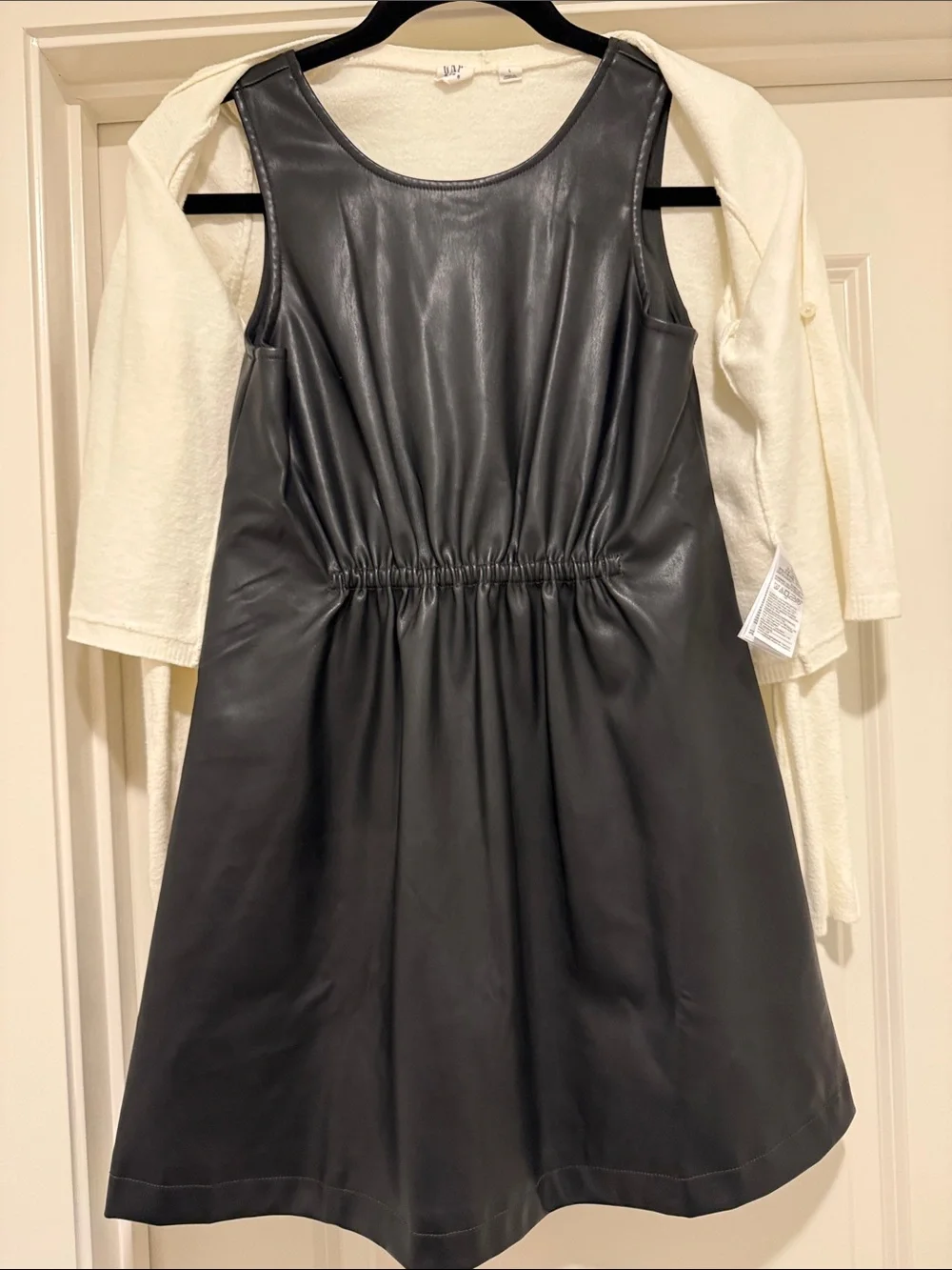 White Cropped Cardigan with Black Bow Over Black Faux Leather Dress